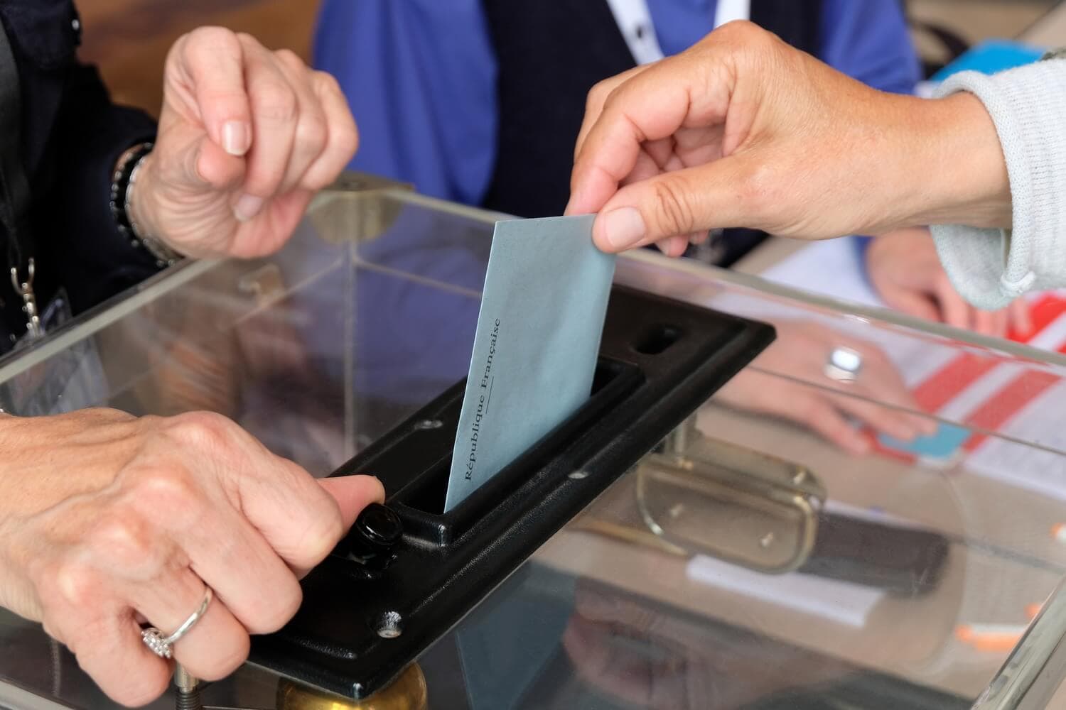Vote glissé dans une urne transparente